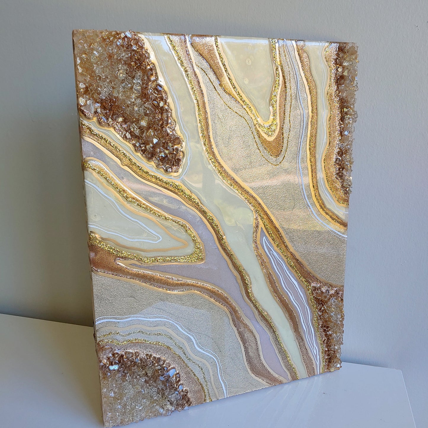 Cream and bronze artwork with glass on wood