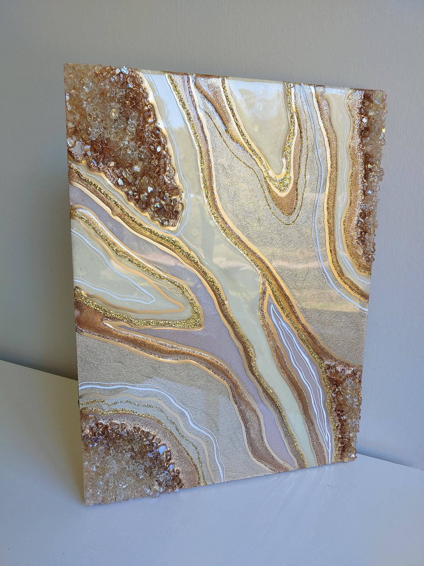 Cream and bronze artwork with glass on wood