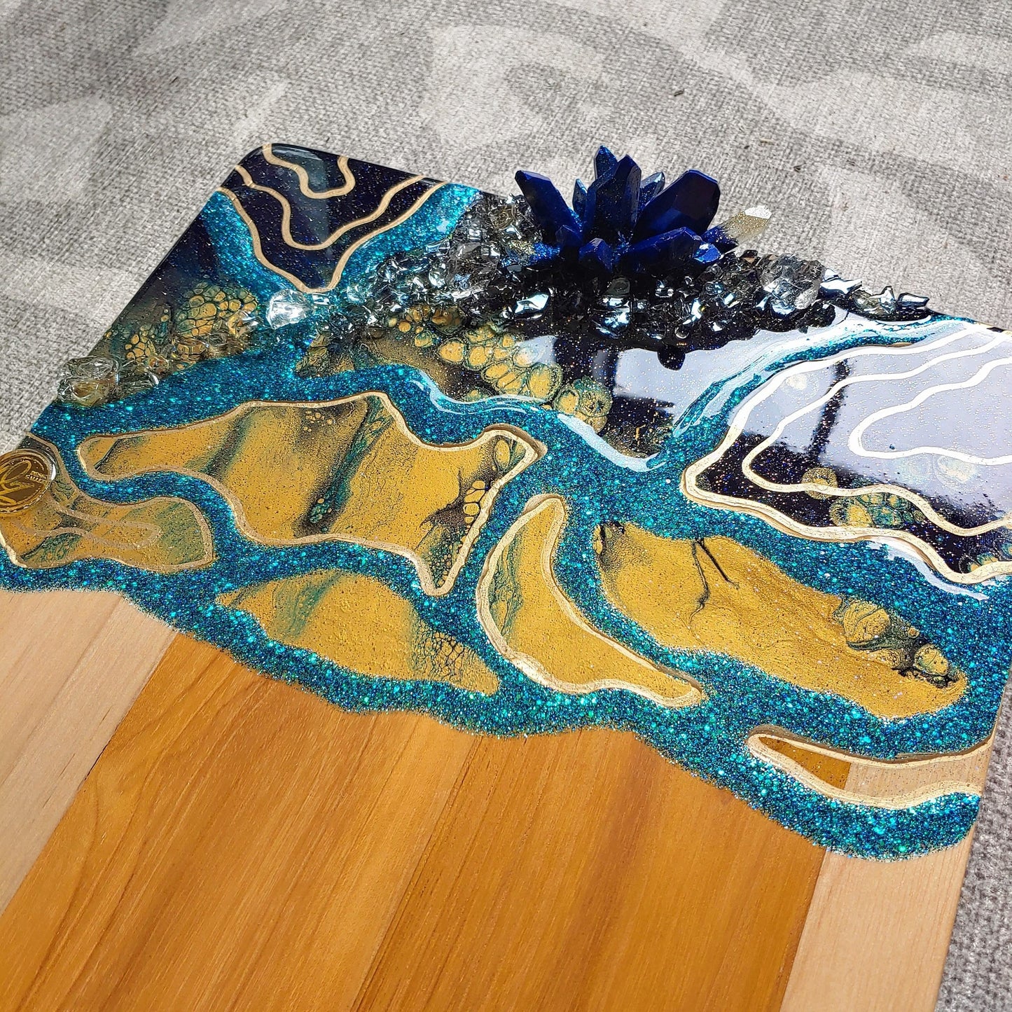 Geode style acacia cheeseboard in navy, turquoise and gold