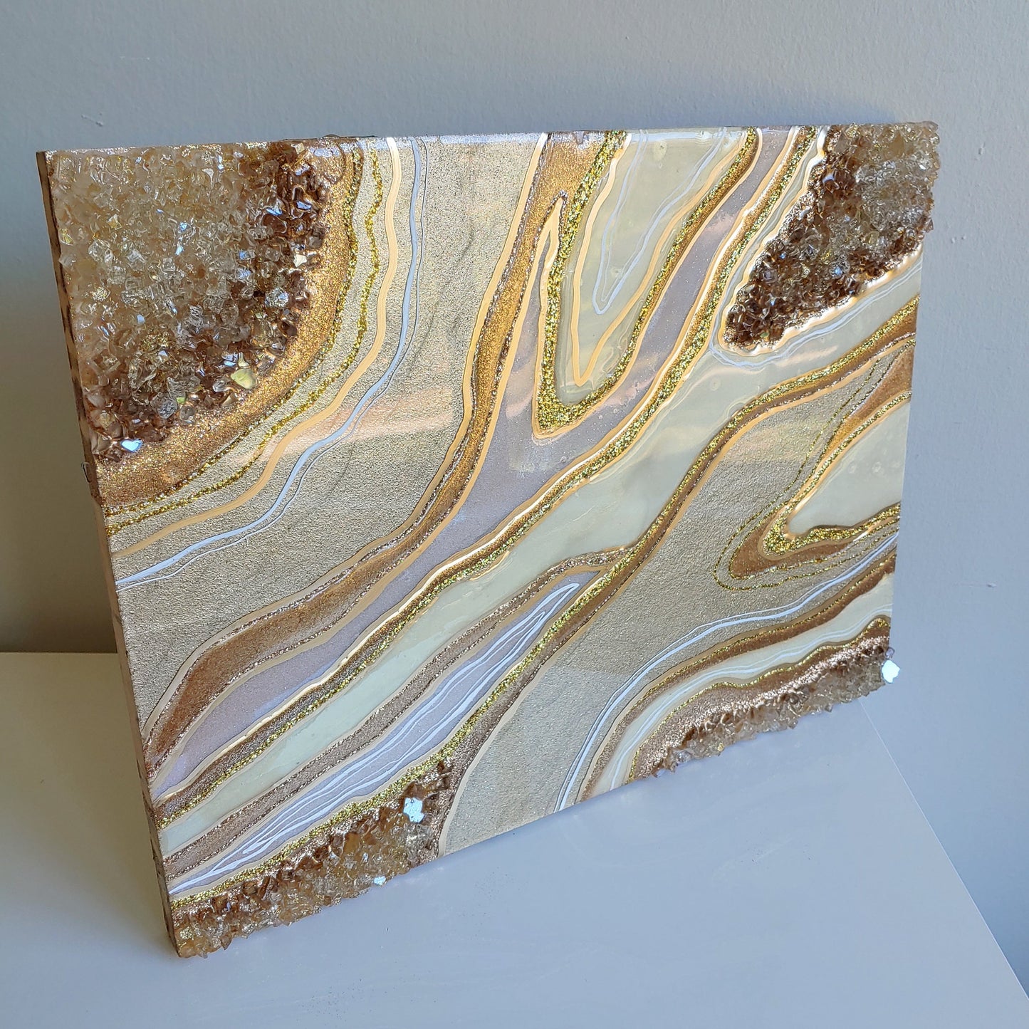 Cream and bronze artwork with glass on wood